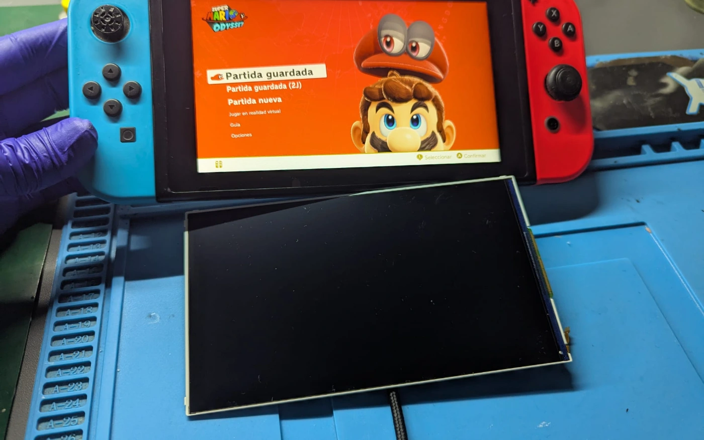 Nintendo Switch funcionando tras el cambio de pantalla, con la antigua al lado