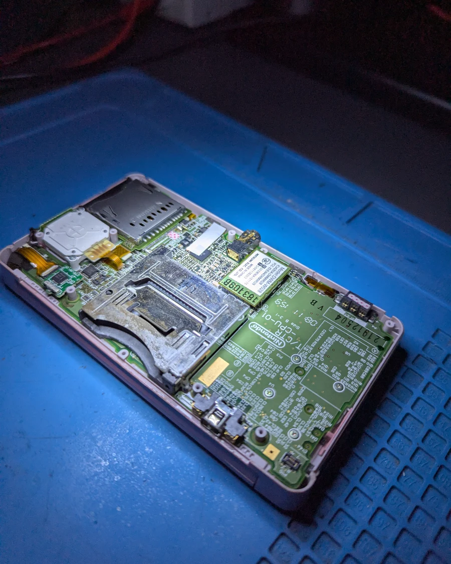 Nintendo DS abierta con la placa y el lector de cartuchos a la vista