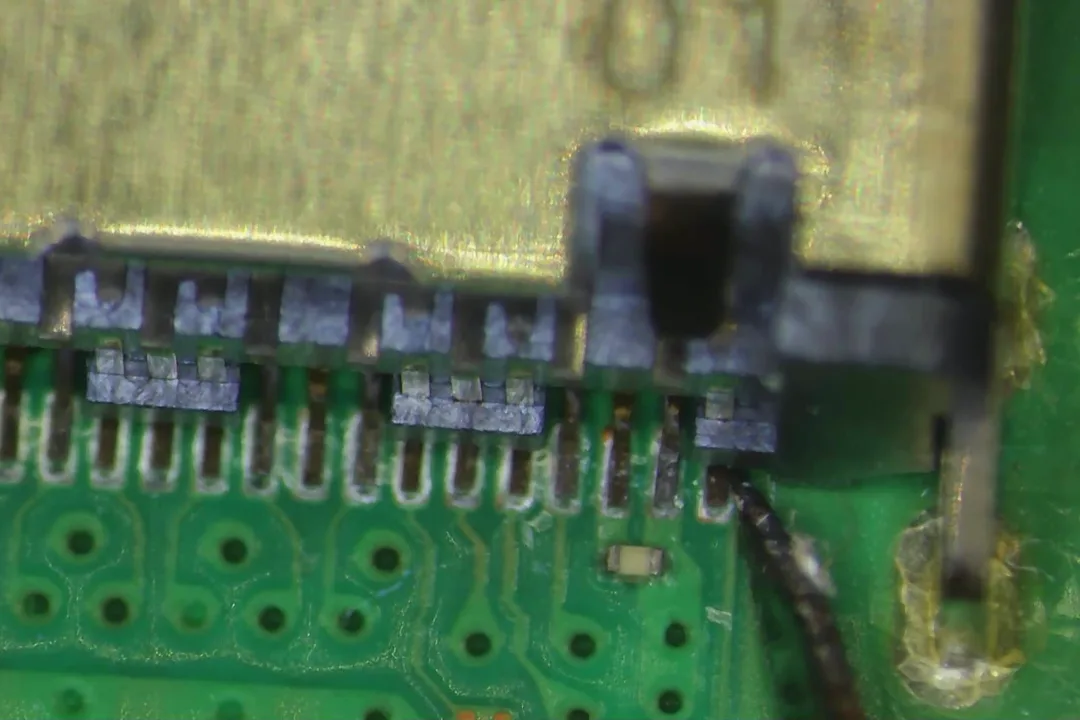 Pines oxidados del conector HDMI de una PS5 al microscopio, en un taller de El Sauzal
