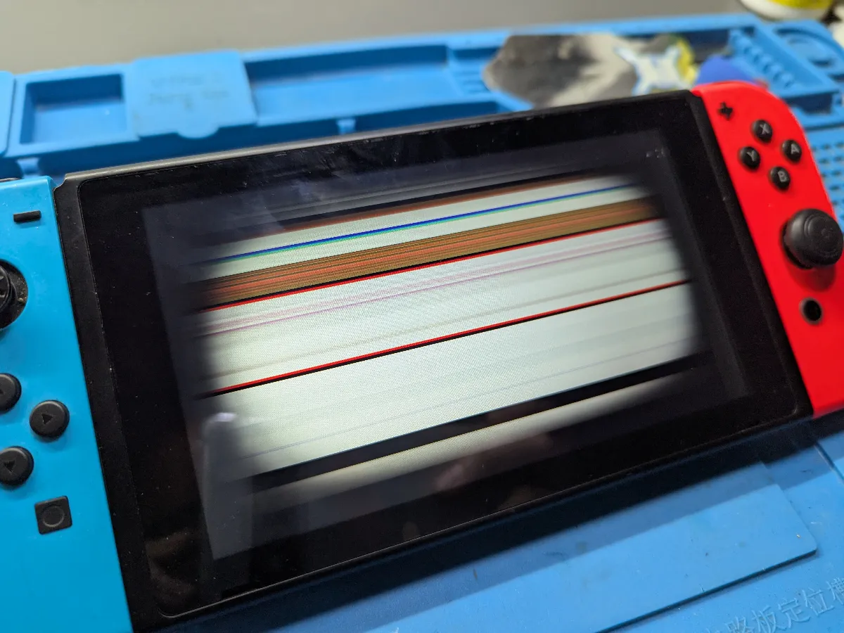 Nintendo Switch con líneas en la pantalla sobre la mesa de trabajo